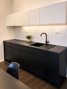 a kitchen with a sink and a black counter at Apartment Modern City in Staré Mesto