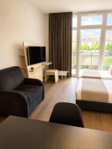 a hotel room with a couch and a bed and a tv at Apartment Modern City in Staré Mesto