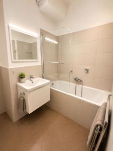 a bathroom with a white tub and a sink and a bath tub at Apartment Modern City in Staré Mesto