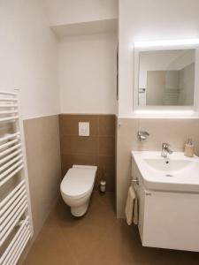a bathroom with a white toilet and a sink at Apartment Modern City in Staré Mesto