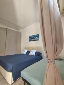 a bedroom with two beds and a curtain at SEA Studio Flat in Misano Adriatico
