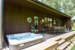 a hot tub on a deck next to a house at Pramogų namelis in Naručionys