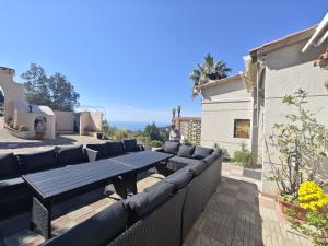 a patio with a wooden table and couches on a fence at Villa Serra Brava mt Gemeinschatspool, 3 Apartments in Lloret de Mar