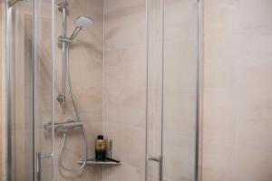 a shower with a glass door with a shower at Fewo-Welz in Bad Kissingen
