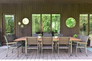 a dining room with a table and chairs and windows at Pramogų namelis in Naručionys