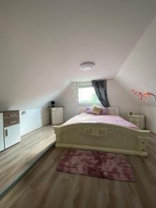 a bedroom with a large bed and a window at Zserbó lak in Kisapostag