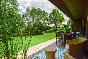 a patio with a table and chairs and a garden at Pramogų namelis in Naručionys +89 photos