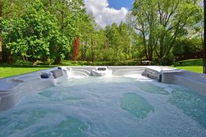 a large hot tub in a yard with trees at Pramogų namelis in Naručionys