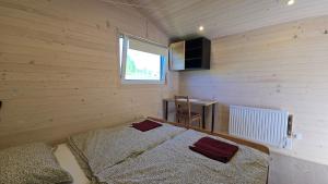 a bedroom with a bed in a wooden room at Ranczo Wyszowate Domki in Wyszowate