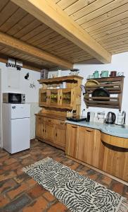 a kitchen with wooden cabinets and a white refrigerator at Hiša Vasenka in Laze v Tuhinju