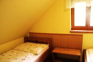 a small bedroom with two beds and a window at Chata pod Lazíkom in Liptovský Hrádok +4 photos