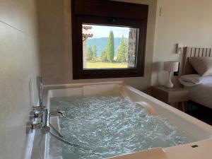 a bath tub with a window in a room at Casas Pirineo, Ainsa in Aínsa