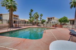 a swimming pool in a courtyard with palm trees at Remote Work Ready! Central Yuma Condo w/ Patio in Yuma