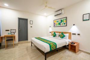 a bedroom with a bed and a desk in it at Treebo The Trio, Karmanghat in Hyderabad +44 photos