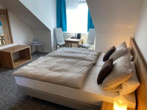 a bedroom with a large bed with pillows at Hotel Hinz in Bad Oldesloe