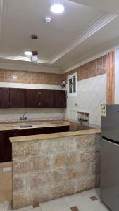 a large kitchen with a counter and a refrigerator at شقق ركن التاسيس in Najran