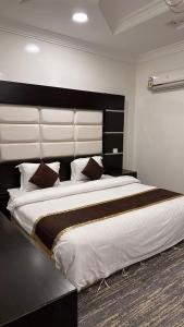 a large bed with a large headboard in a bedroom at شقق ركن التاسيس in Najran
