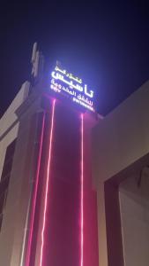 a neon sign on the side of a building at شقق ركن التاسيس in Najran
