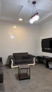 a living room with a couch and a flat screen tv at شقق ركن التاسيس in Najran