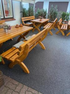 a group of wooden picnic tables and benches at Hotel Hinz in Bad Oldesloe