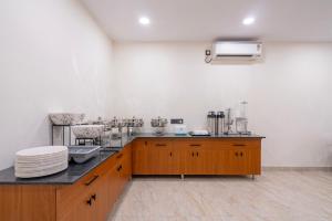a kitchen with wooden cabinets and a counter top at Treebo The Trio, Karmanghat in Hyderabad