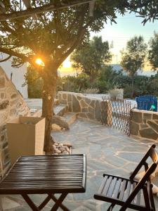 a bench and a tree on a stone patio at OrkiSEA-Orkos beach in Mikri Vigla