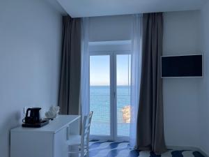 a room with a desk and a window with the ocean at Metasuites Beach in Meta