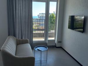 a living room with a couch and a large window at Itown Apartments in Odesa