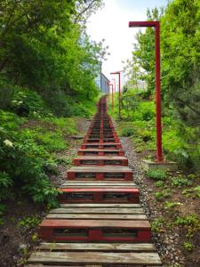 a wooden path with a red pole and trees at Itown Apartments in Odesa +6 photos