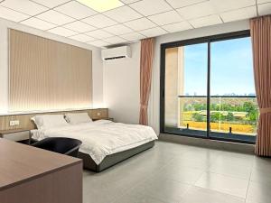 a bedroom with a bed and a large window at Modera Residence Grand Phnom Penh, Serviced Apartments in Phnom Penh
