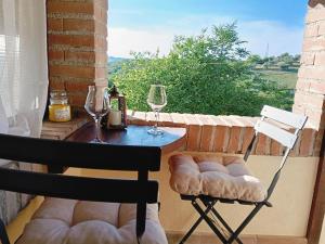 a table and two chairs on a balcony with wine glasses at Casa di Ruggi in Tenaglie