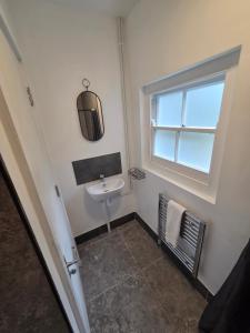 a small bathroom with a sink and a window at St Marys Cottages 1 in Dover +27 photos