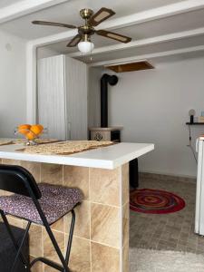 a kitchen with a table and a ceiling fan at Zserbó lak in Kisapostag