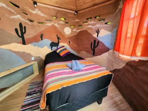 a bedroom with a mural of a room with a bed at Casa Voyage Hostel in San Pedro de Atacama