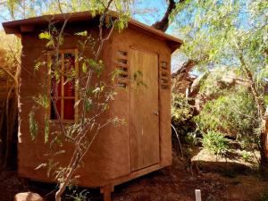 a small house with a door in the woods at Casa Voyage Hostel in San Pedro de Atacama