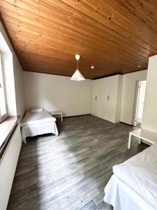 a room with two beds and a wooden ceiling at Lägenhet Svängsta in Svängsta