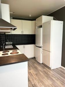 a kitchen with white cabinets and a white refrigerator at Lägenhet Svängsta in Svängsta +4 photos