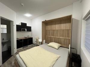 a bedroom with a large bed and a kitchen at Fit-Relax Apartments Meersburg mit eigenem Sportstudio in Meersburg