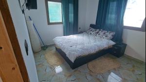 a small bedroom with a bed with blue curtains at Villa Bingo & Piscine in El Jadida +2 photos