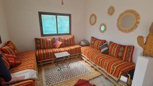 a living room with two couches and a table at Villa Bingo & Piscine in El Jadida