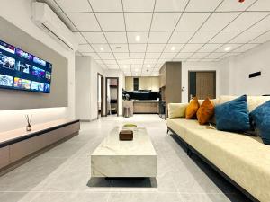 a living room with a couch and a tv at Modera Residence Grand Phnom Penh, Serviced Apartments in Phnom Penh