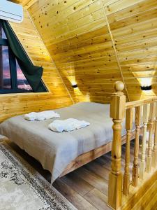 a bedroom with a bed in a wooden cabin at Tengri House A-Frame Issyk-Kul in Kaji-Say