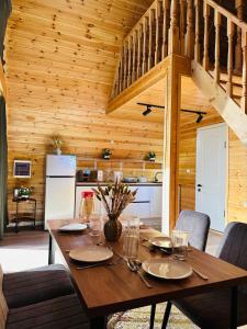 a wooden dining room with a table and a kitchen at Tengri House A-Frame Issyk-Kul in Kaji-Say