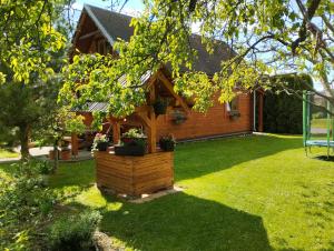 a wooden house with a flower box in the yard at Chata pod Lazíkom in Liptovský Hrádok