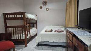 a bedroom with a bunk bed and a desk with a television at Bell Ville in Bell Ville