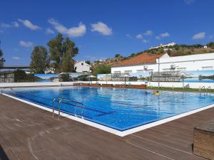 a large swimming pool next to a building at Casinha Serrinha in Mértola
