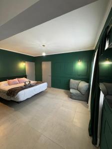 a bedroom with green walls and a bed and a chair at Tandem - Espacio para dos - Cama King - Parking in Maipú