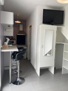 a kitchen with a table and a desk with a mirror at Studio de plein pied avec terrasse in Joncherey