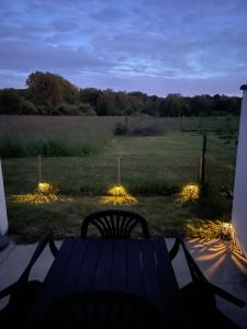 a table and chairs sitting on a porch with lights at Studio de plein pied avec terrasse in Joncherey