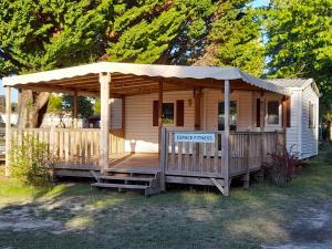 a wooden cabin with a porch with a canopy at danseuse 33 in Parentis-en-Born